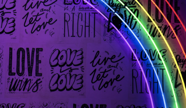 Rainbow lights with slogans such as “Love Wins” in the background
