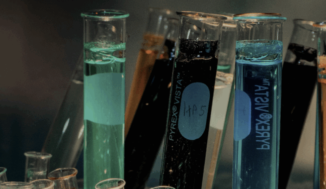 Zoomed in shot of the tops of test tubes filled with colored liquid