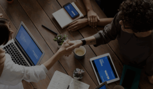 Two people shaking hands over a table